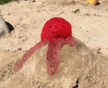 a vulcano created in sand with vinegar and baking soda spilling out from the top